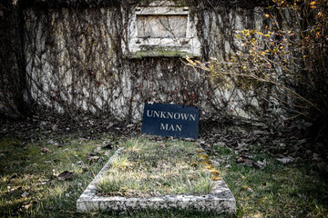 The unkempt grave with a fallen plaque with the inscription Unknown man..