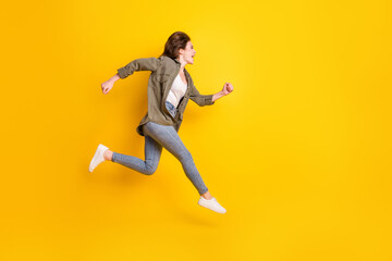 Fototapeta na wymiar Full length body size view of attractive cheerful glad girl jumping running marathon isolated over bright yellow color background