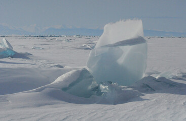 Piece of ice against the background of mountains and Lake Baikal