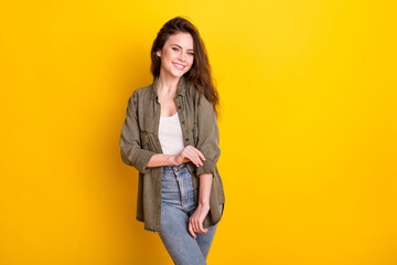 Photo of adorable sweet young lady wear brown shirt adjusting clothes empty space isolated yellow color background