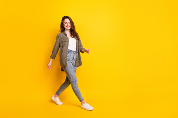 Full length body size view of attractive cheerful girl wearing cozy clothing going isolated over bright yellow color background