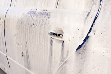 Blue car in foam at a car wash