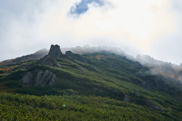 Rocks and stones in the mountains in fog and clouds.  Mountains in the fog background