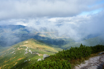 Amazing view on a mountains in a fog and clouds. Cloud scape in mountains. Wild nature