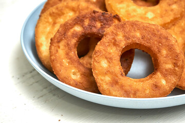 Fried curd donuts in a blue plate close up