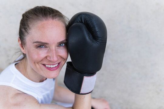 Happy female boxer with boxing glove
