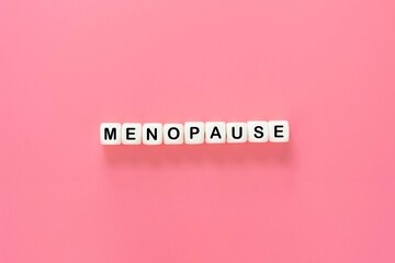 Menopause word abstract text, wooden blocks over pink background