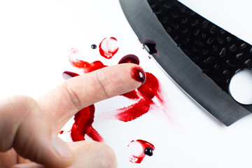 Man cut her finger with a knife. Finger with blood. Red Bloody fingerprints on the white...