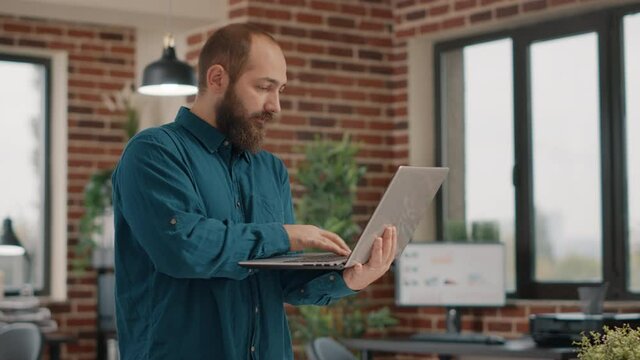 Happy man enjoying satisfaction after reading good news on laptop. Entrepreneur celebrating successful achievement and win because of business project and presentation. Positive employee