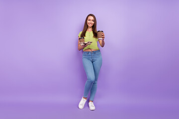 Fototapeta na wymiar Full length body size view of attractive cheerful girl holding two cups latte giving you isolated over purple violet color background
