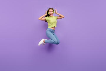 Full length body size view of pretty cheerful girl jumping listening rock having fun isolated over purple violet color background