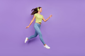 Fototapeta na wymiar Full length body size view of lovely cheerful girl jumping listening pop single going isolated over purple violet color background