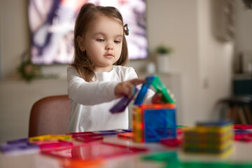 Little girl playing with colorful blocks