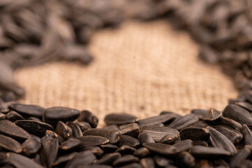 Fried black sunflower seeds scattered on the table, close-up, selective focus.