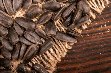 Fried black sunflower seeds scattered on the table, close-up, selective focus.