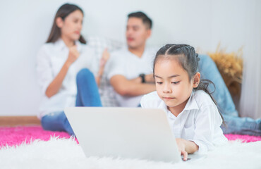 Happy asian family people leisure in bedroom together. Father and mother with daughter relaxing and using laptop computer on bed
