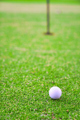 Golf ball on lip of cup close up, Golf ball on the lawn