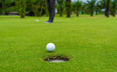 Golfer putting golf ball on the green golf, lens flare on sun set evening time, Pro Golf long...