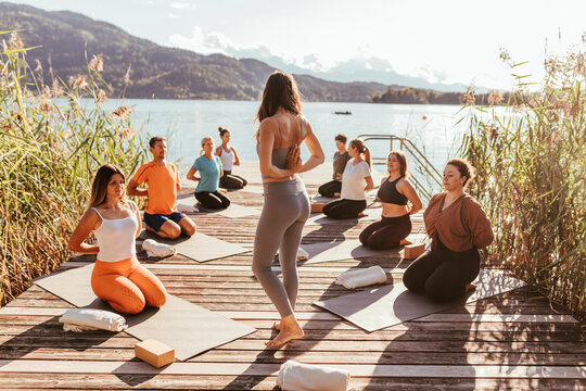 Female instructor teaching Pashchima Namaskarasana during yoga class