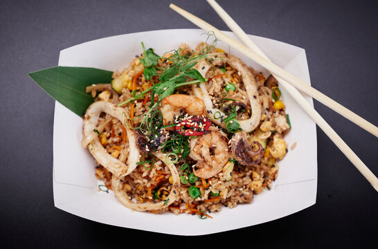 Top view of fried rice with seafood and vegetables prepared in Chinese wok as vegetarian food concept. Chinese healthy fast food. Shrimps, squid and octopus with rice stir fry. High quality image