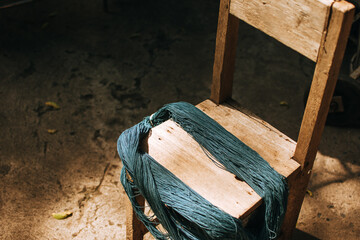 Indigo-dyed threads on a wooden chair. Cotton that has been dyed in its natural color.