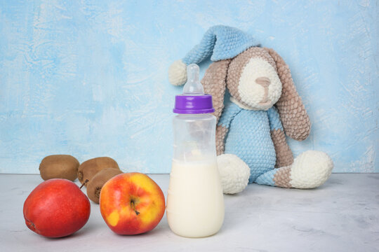 Lactation And Healthy Food. Breastfeeding Mom's Diet. Brest Milk, Children's Toy, Fruits On Blue Background. Copyspace