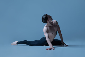 Portrait of young man, flexible male ballet dancer dancing isolated on old navy studio background. Art, motion, inspiration concept.