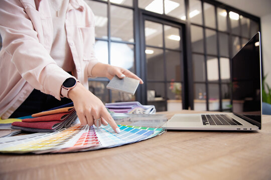 Closeup decorator, interior and graphic designer, architect is choosing catalogue colors ral for web project