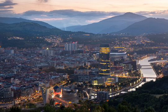 Spain, Biscay, Bilbao, Riverside city at dusk