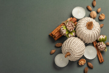 Autumn composition with crocheted pumpkins, candles, spices, and traditional decor