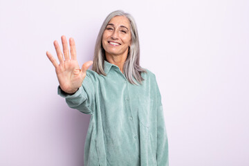 middle age gray hair woman smiling and looking friendly, showing number five or fifth with hand...