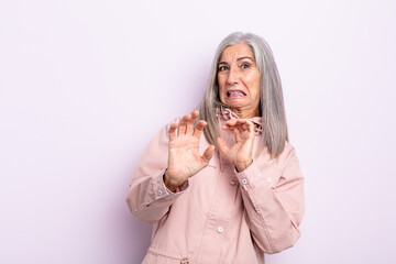 middle age gray hair woman feeling disgusted and nauseous, backing away from something nasty,...