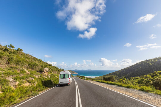 Van driving along coastal asphalt road in summer