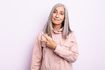 middle age gray hair woman feeling happy, positive and successful, with hand making v shape over...