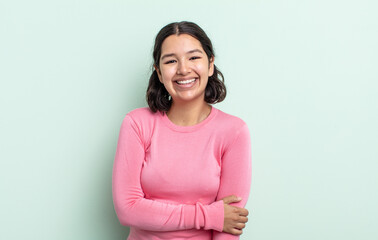 pretty teenager woman laughing shyly and cheerfully, with a friendly and positive but insecure...