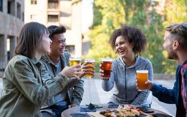 Happy friends having fun, group of millennials friends cheering at bar together