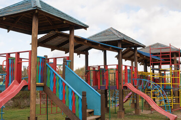 Fototapeta na wymiar Empty children's swing in the park, wooden benches, slides, sports equipment.