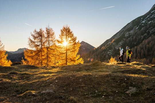 Two people hiking inEnnstalAlps at autumn sunset