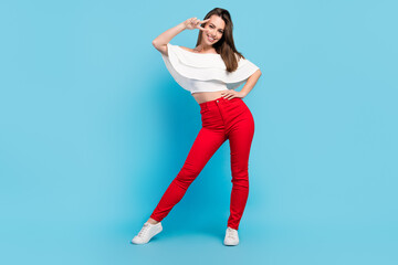 Fototapeta na wymiar Full size photo of impresssed brunette young lady show v-sign wear blouse jeans isolated on blue color background