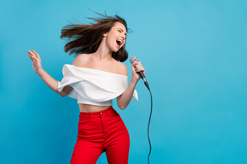 Photo of joyful happy positive woman sing karaoke wind blow hair star celebrity isolated on blue color background - obrazy, fototapety, plakaty