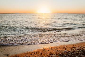 Beautiful sunset on the sea on the beach in summer, amazing summer landscape with waves