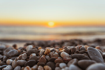 Quiet calm beach at sunset. Beautiful textured pebbles in the foreground . The concept of serenity and relaxation