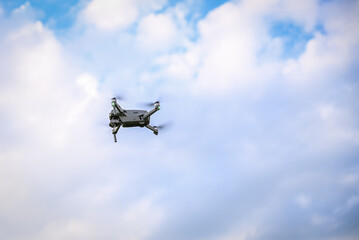 Fototapeta na wymiar Photo of a quadrocopter against a blue sky with clouds