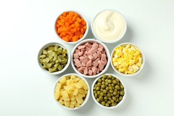 Bowls with Olivier salad ingredients on white background
