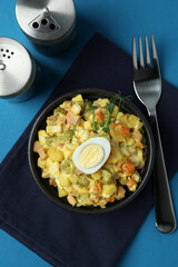 Concept of tasty food with Olivier salad on blue background