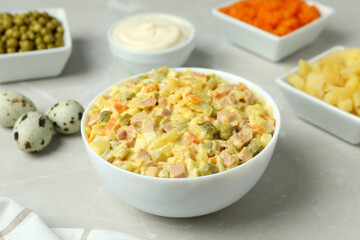 Olivier salad and ingredients on light background