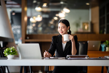 Shot of a asian young business Female working on laptop computer in her workstation.Portrait of Business people employee freelance online marketing e-commerce telemarketing concept.