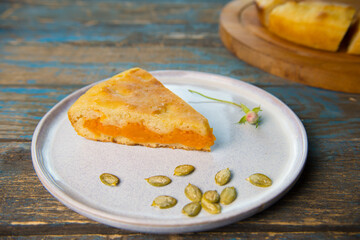 A slice of homemade pumpkin pie baked for the holiday on a white plate.

