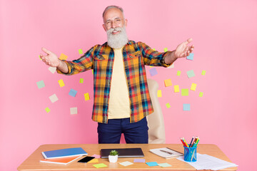 Photo of funny friendly age gentleman wear plaid shirt siting table inviting you study isolated stickers pink color background