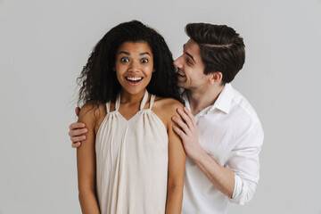 European unshaven man hugging her smiling black girlfriend
